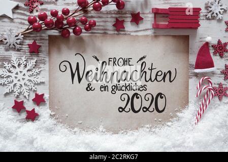 Papier mit Deutschen Kalligraphie Frohe Weihnachten und ein Glueckliches 2020 bedeutet, frohe Weihnachten und einen guten Rutsch ins Jahr 2020. Rot Weihnachten Dekoration wie Kugel, Stockfoto