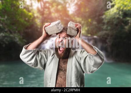 Starke Karateka bricht ein Ziegelstein auf den Kopf Stockfoto