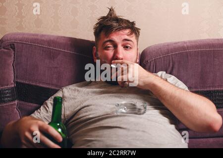 Alkoholsüchtiger Mann in Depression. Betrunkener Mann rauchen Zigarette. Stockfoto