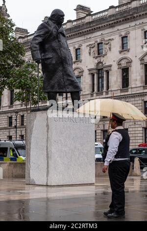 Westminster, London, Großbritannien. Juni 2020. Die Statue von Winston Churchill vor dem Palast von Westminster wurde aufgedeckt, nachdem sie durch die Maßnahmen verhindert wurde, dass sie während der Proteste von Black Lives Matter weiter zerstört wird. Der französische Präsident Emmanuel Macron besucht London zum 80. Jahrestag der Appel-Rede von Charles de Gaulle, die als Ursprung des französischen Widerstands gegen die deutsche Besatzung während des Zweiten Weltkriegs gilt, so dass die Statue enthüllt wurde. Wächter des historischen Erbes, ständiger Wächter Stockfoto