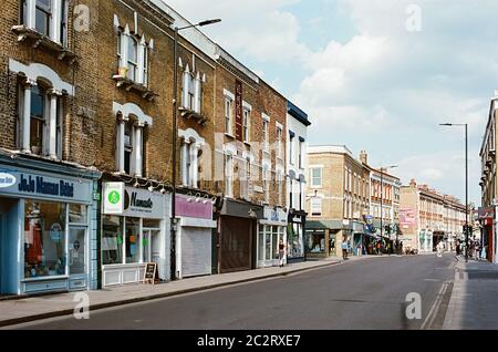 Church Street, Stoke Newington, North London, Großbritannien, Blick nach Osten, mit Geschäften und Fußgängern Stockfoto