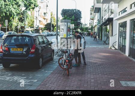 Tel Aviv/Israel-12/10/18: Touristen denken an die Anmietung dockless Mobike Fahrräder auf einer Straße in Tel Aviv. Mobike ist eines der größten Fahrrad- Stockfoto