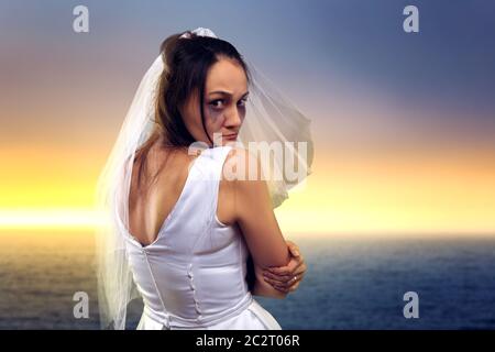 Tränenreiche Braut auf dem Hintergrund auf das Meer und Sonnenuntergang Stockfoto