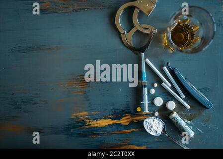 Druggy Kit, Dosis im Spoon, sucht problem Konzept. Pillen sind auf den Tisch gelegt, die Spritze für Dosis, Alkohol und Handschellen Stockfoto