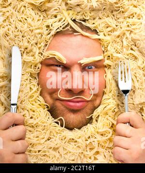 Lustiger Mensch mit Gabel und Messer in pasta Stockfoto