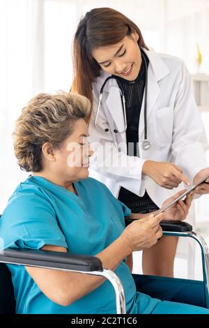 Arzt mit Tablette mit alten Patienten Stockfoto