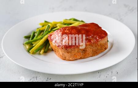 Meatloaf mit Tomatensauce und grünen Bohnen Stockfoto