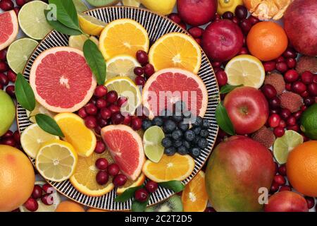 Große gesunde immun fördernde frische Obstsammlung auf einem runden Teller und lose. Super Essen sehr hoch in Antioxidantien, Vitamine & Ballaststoffe. Stockfoto