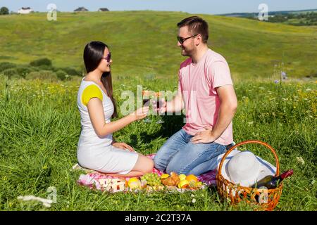 Junges Paar, das beim Picknick Wein trinkt Stockfoto