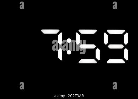Echte weiße LED Digitaluhr auf einem schwarzen Hintergrund angezeigt Zeit 7:59 Stockfoto