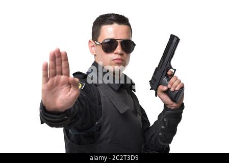 Seriuse Cop in Sonnenbrille Posen mit Gewehr, schwarze Uniform mit Schutzkleidung, weißen Hintergrund. Polizisten in spezielle Munition Stockfoto