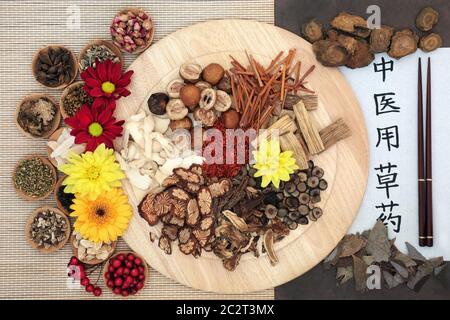 Chinesische Kräuter mit Kalligraphie-Schrift auf Reispapier mit Übersetzungslesen als traditionelle chinesische Kräuter, die in der Kräutermedizin verwendet werden. Stockfoto