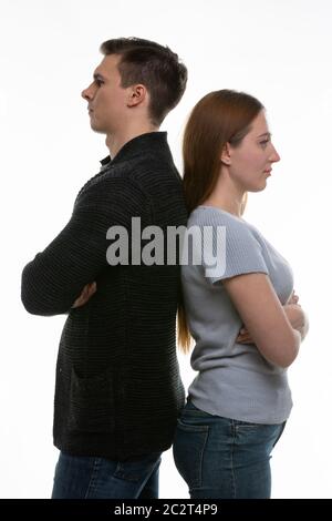 Ein Mann und eine Frau stehen mit dem Rücken zueinander, wobei ihre Arme auf ihren Truhen gefaltet sind Stockfoto