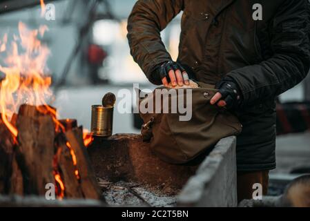 Stalker, männliche Person Wärmt die Hände am Feuer. Post-apokalyptischen Lebensstil mit Gasmaske, Doomsday, Stockfoto