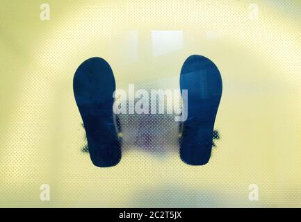 Ansicht von unten durch das Glas des Mannes Schuhe Füße Stockfoto