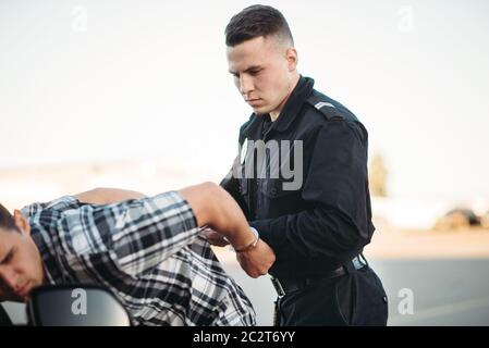 Polizist Verhaftungen der Autodieb auf der Straße. Spindel am Arbeiten. Schutz konzept, professionelle Sicherheitssteuerung Stockfoto