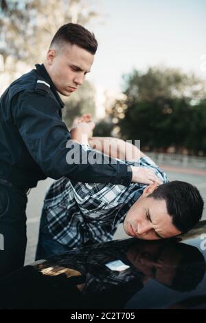 Polizist Verhaftungen der Autodieb auf der Straße. Spindel am Arbeiten. Schutz konzept, professionelle Sicherheitssteuerung Stockfoto