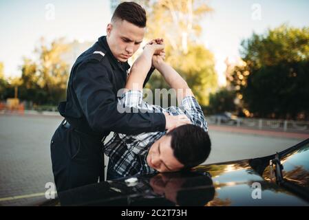 Polizist Verhaftungen der Autodieb auf der Straße. Spindel am Arbeiten. Schutz konzept, professionelle Sicherheitssteuerung Stockfoto