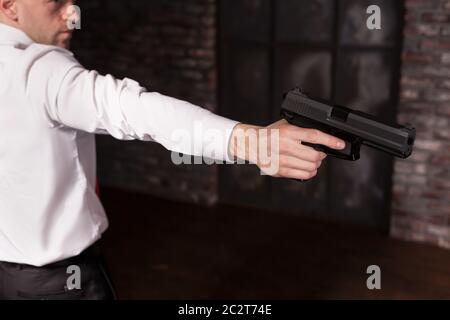 Ernsthafte Mörder angeheuert in rote Krawatte soll eine Waffe. Professionelle Geheimagenten Konzept. Assassine mit Pistolen, Wallpaper, Hintergrund oder Plakat. Auftragskiller Stockfoto