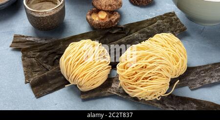 Udon Nudeln, eine panoramische Nahaufnahme mit getrockneten Meer Gemüse Kelp und Shiitake-pilze, Ramen Zutaten Stockfoto