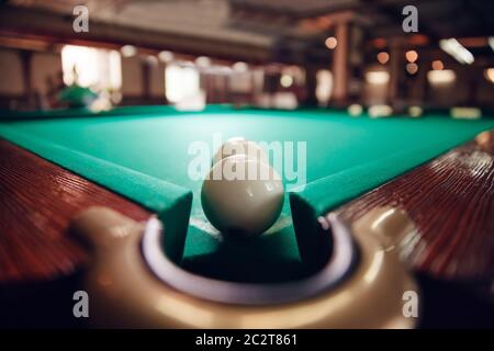 Zwei weiße Billardkugeln in der Nähe der Tasche fokussiert Stockfoto