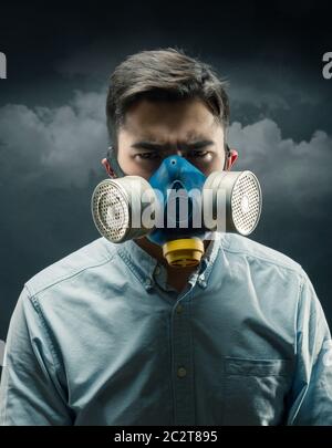 Junger Mann in einer Gasmaske mit Luftverschmutzung Stockfoto