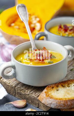 Kürbissuppe mit knusprigem Speck aus nächster Nähe. Stockfoto