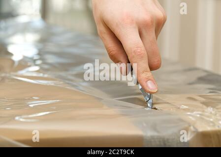 Auspacken des Bettes mit grauer Matratze. Umzug in neue Haus Konzept. Selektive Fokus. Stockfoto