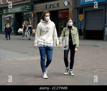 Junges Paar, Gehen Hände haltend, Masken tragen, während Corona Virus entsperren. Stockfoto