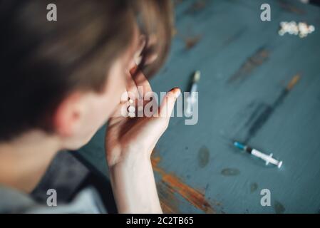 Männliche Junkie akzeptieren grugs, die Spritze auf dem Tisch für den Hintergrund. Sucht Konzept, Leute süchtig Stockfoto