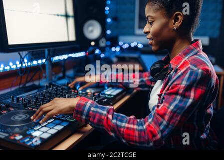 Weibliche Toningenieur bei der Fernbedienung arbeiten im Tonstudio. Musiker am Mischpult, Professional Audio Mixing Stockfoto