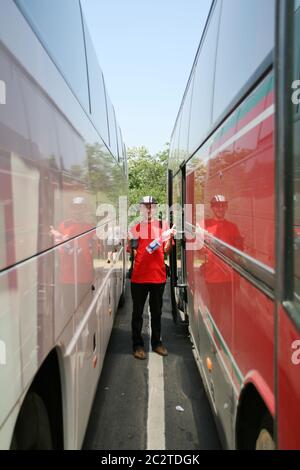 Glückliche Reisende zwischen zwei Bussen Stockfoto