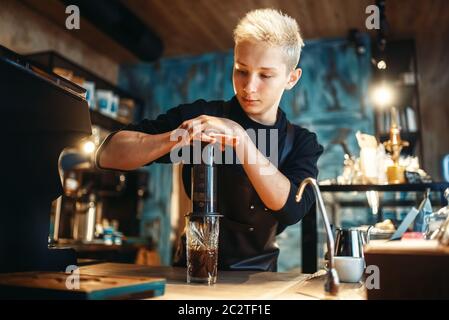 Junge männliche Barista macht frischen Espresso, Kaffee schwarz Vorbereitung im Cafe. Barkeeper arbeiten in der Cafeteria, barmixer Besetzung Stockfoto