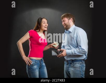 Frau, die Geld aus der Brieftasche des Mannes nimmt Stockfoto