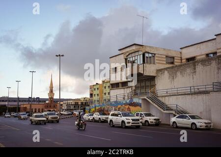 Abha / Saudi-Arabien - 23. Januar 2020: Polizist auf dem Motorrad in den Straßen von Abha mit Moschee im Hintergrund Stockfoto