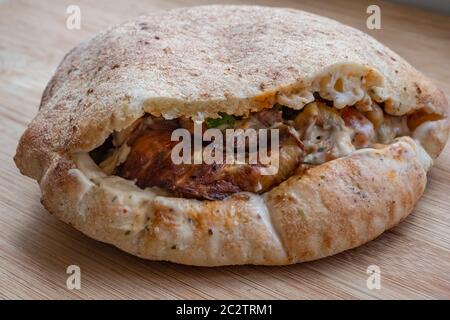 Sabich oder sabih Sandwich serviert in Pita Brot gefüllt mit gebratenen Auberginen, hart gekochte Eier, Salat, Petersilie und Tahini-Sauce. Sabich basiert auf einem traditionellen irakischen jüdischen Gericht, das für Schabbat zubereitet wurde und von irakischen Juden nach Israel gebracht wurde, die in den 1940er und 1950er Jahren umzogen. Stockfoto