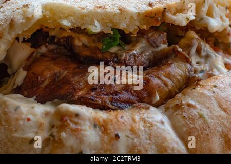 Sabich oder sabih Sandwich serviert in Pita Brot gefüllt mit gebratenen Auberginen, hart gekochte Eier, Salat, Petersilie und Tahini-Sauce. Sabich basiert auf einem traditionellen irakischen jüdischen Gericht, das für Schabbat zubereitet wurde und von irakischen Juden nach Israel gebracht wurde, die in den 1940er und 1950er Jahren umzogen. Stockfoto