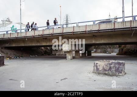 Abha / Saudi-Arabien - 23. Januar 2020: Saudi-Männer gehen auf Brücke über trockenes Flussbett Stockfoto