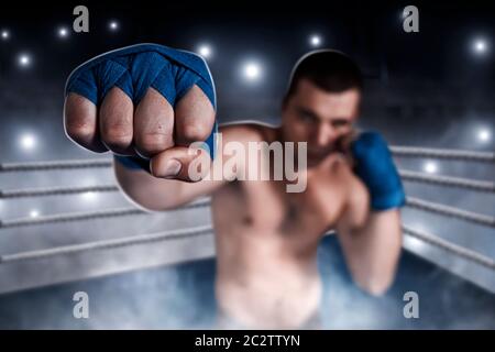 Boxer in blau Handgelenk umhüllt das Training. Boxring auf dem Hintergrund. Leistung im Boxen. Stockfoto