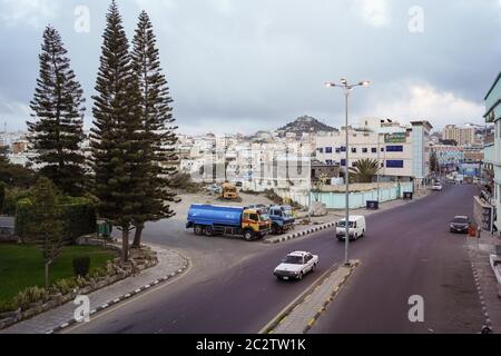 Abha / Saudi Arabien - 23. Januar 2020: Abha Stadtpanorama mit Bäumen, Öltransportern und Berg mit Lichtern im Hintergrund Stockfoto