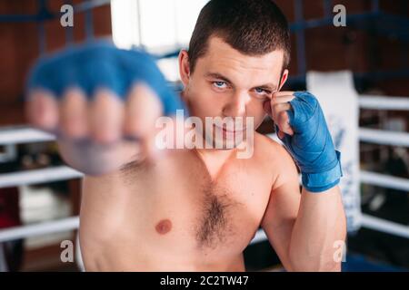 Boxer in blau Handgelenk umhüllt das Training. Boxring auf dem Hintergrund. Leistung im Boxen. Stockfoto