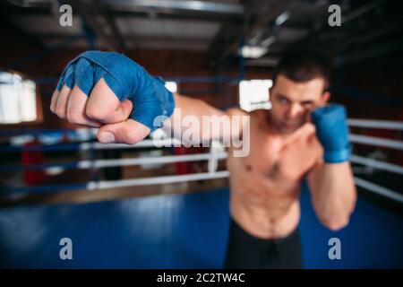 Boxer in blau Handgelenk umhüllt das Training. Boxring auf dem Hintergrund. Leistung im Boxen. Stockfoto