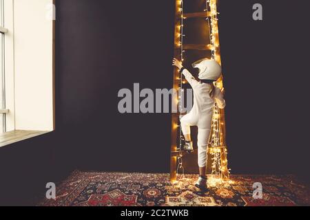 Astronaut futuristische Mädchen mit weißen Uniform in voller Länge und Helm tragen silberne Schuhe Stockfoto