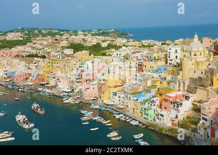 Atemberaubende Aussicht auf Procida im sonnigen Sommertag. Bunte Häuser, Boote und Yachten in der Marina Corricella, Insel Procida, Italien. Stockfoto