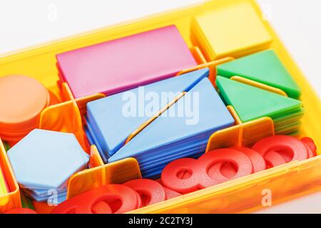 Bunte Figuren und Zahlen für Kinder in einer Schachtel. Ein Werkzeug, um das Denken von Kindern zu entwickeln. Stockfoto