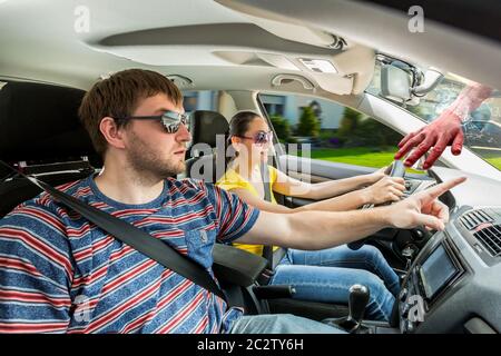 Pärchen fährt das Auto, blutige menschliche Hand im Fenster Stockfoto