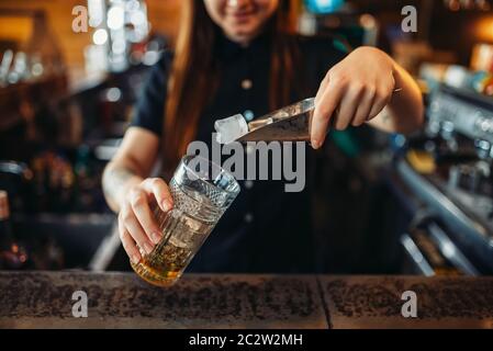 Weibliche Barkeeper mixen an der Theke im Pub. Frau Barkeeper bereitet trinken. Barkeeper Besetzung Stockfoto