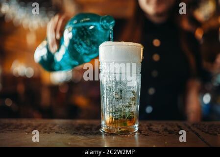 Weibliche Barkeeper gießt kohlensäurehaltiges Wasser in ein Glas. Frau Barkeeper mixen an der Theke im Pub. Barkeeper Besetzung Stockfoto