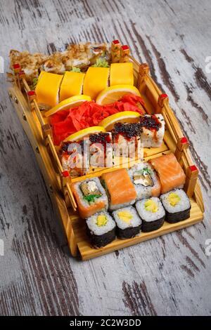 Traditionelle japanische Küche. Ein tolles Set für verschiedene Arten von Sushi. Restaurant Präsentation von Lebensmitteln. Einfache Holz- Hintergrund. Stockfoto