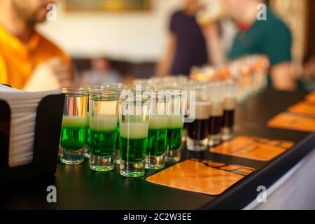 Alkoholisches Getränk, kreatives Stimulans und unkonventionelle Lifestyle-Konzept. Grüner alkoholischer Cocktail an der Bar. Schuss. Stockfoto